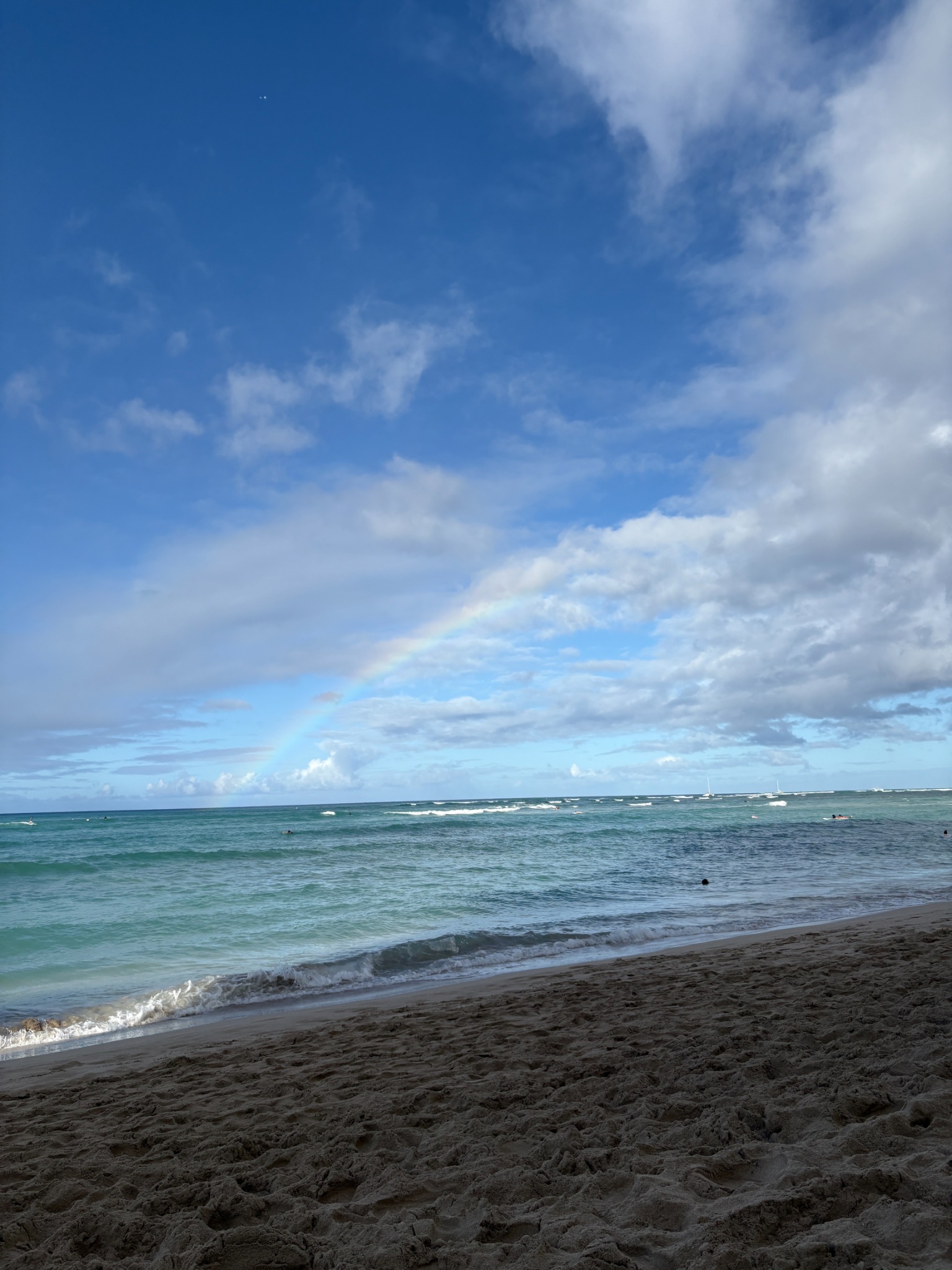 Ocean, sky and a subtle rainbow at the beach in Honolulu